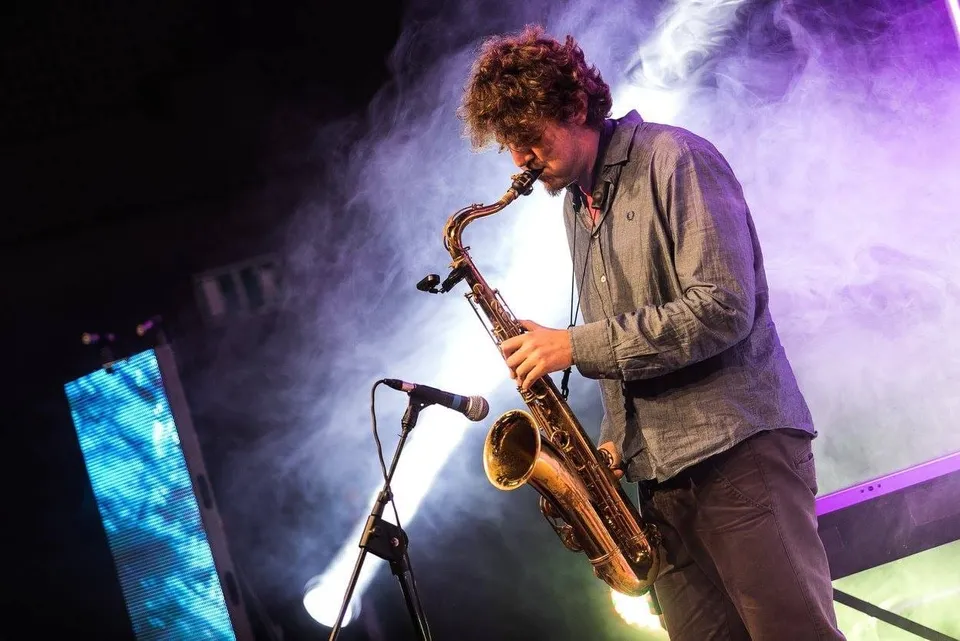 Francesco Pafundi suona il sax tenore tra il fumo e le luci viola del palco