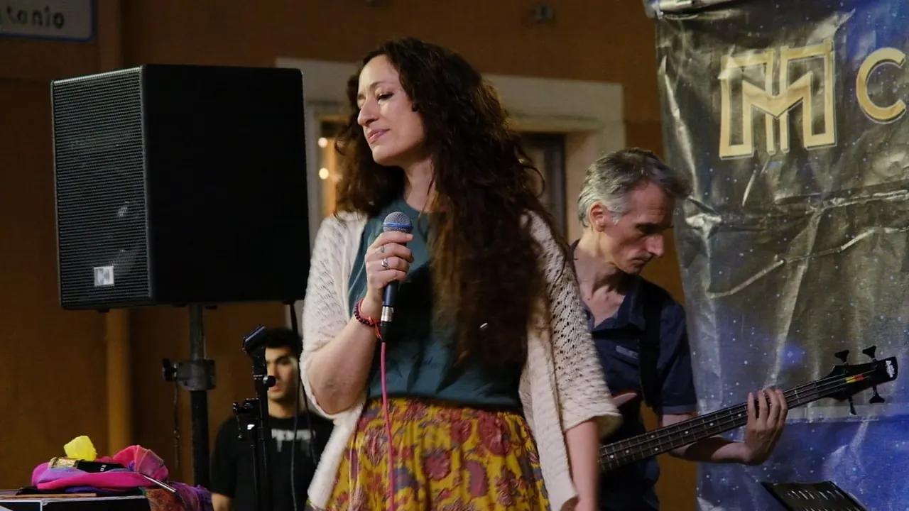 Serena Scocca sorride al microfono durante un concerto